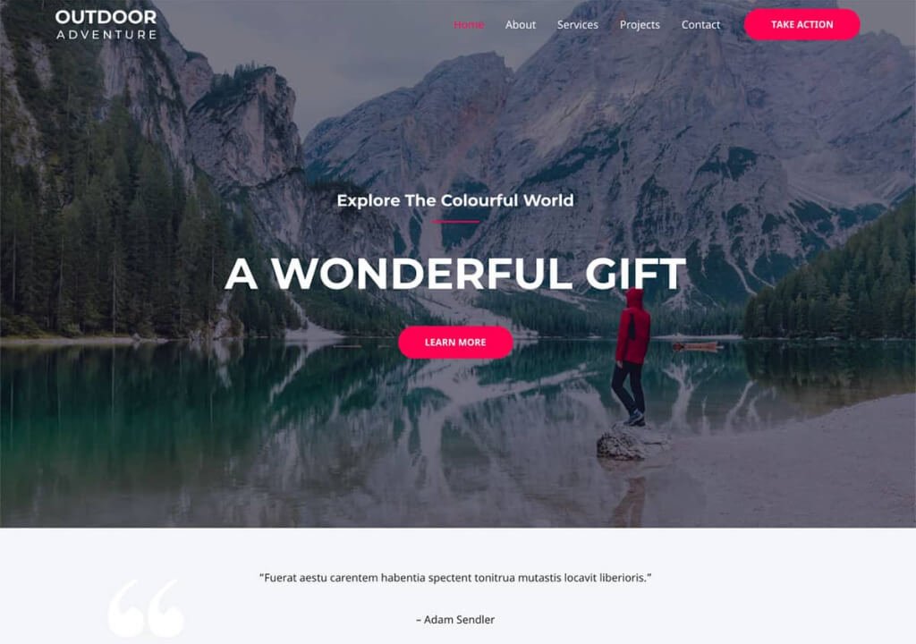 Scenic mountain lake with a person in a red jacket standing on a rock.